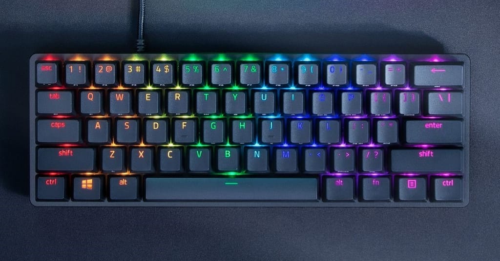 Illuminated view of gaming Razer Huntsman Mini keyboard on black desk mat