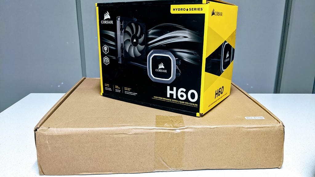 The FormD T1 shipping box with a yellow Corsair H60 AIO box for size comparison
