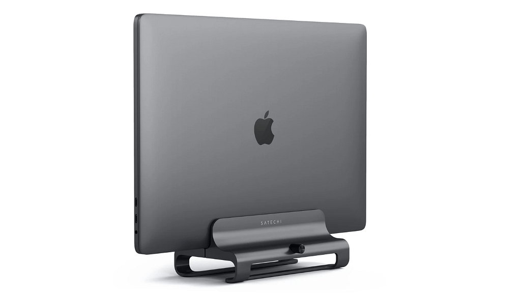 An Apple laptop held vertically by the aluminum Satechi Laptop stand against a plain background